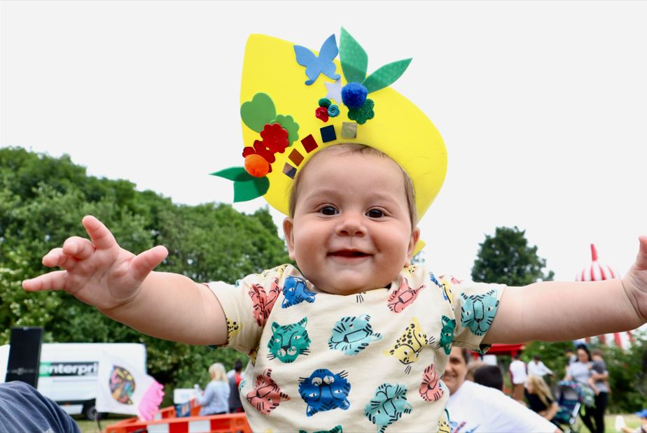 A smiling baby at a festival