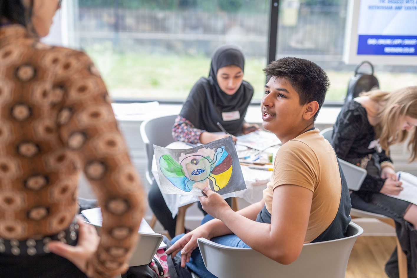 A young person shows if their art work.