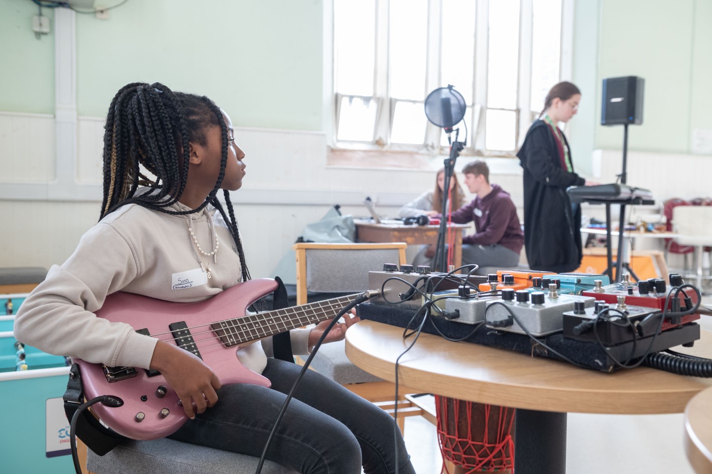 A young person plays the guitar.