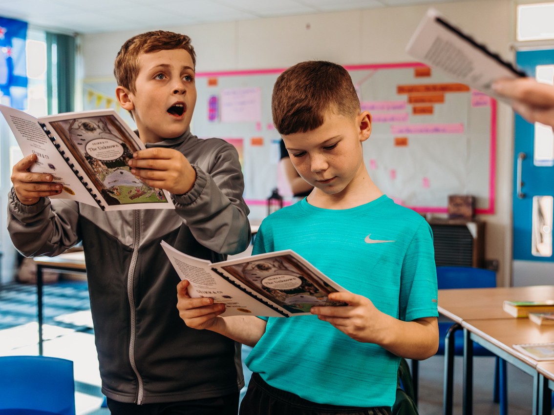 Two boys read from books.