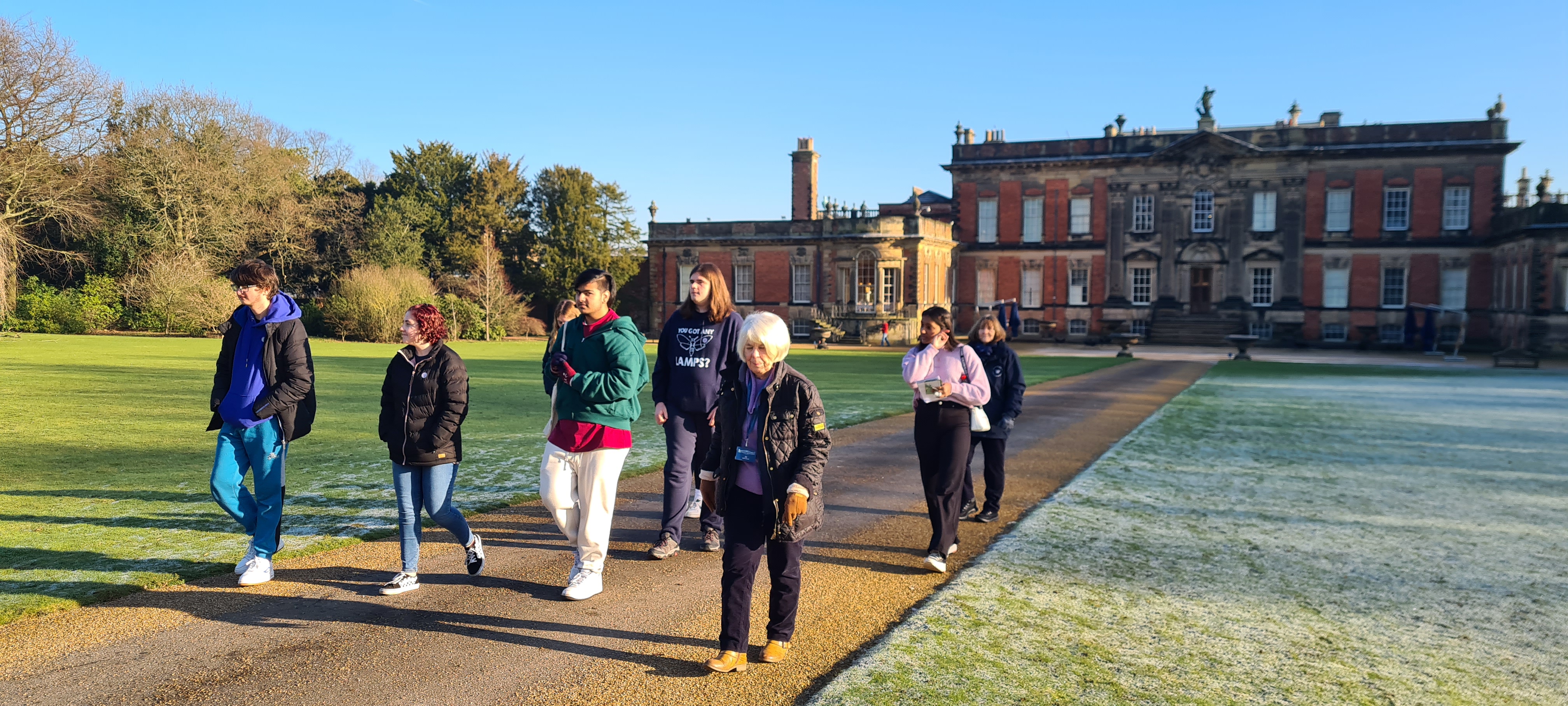 A group of young people stand outside Wentworth Woodhouse on a sunny day.